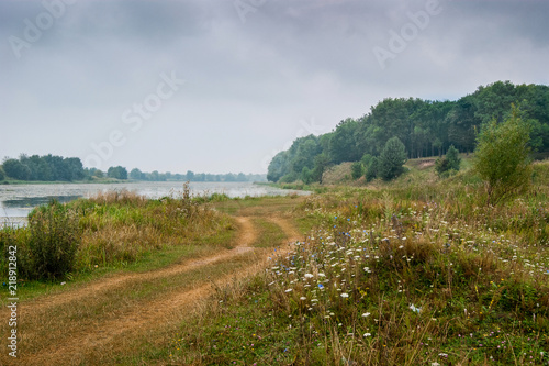The road to the forest along the river. Autumn landscape  cloudy weather_