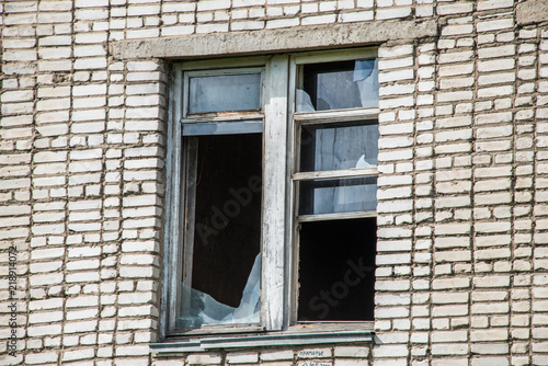 Broken Windows and glass in an old, abandoned brick house photo