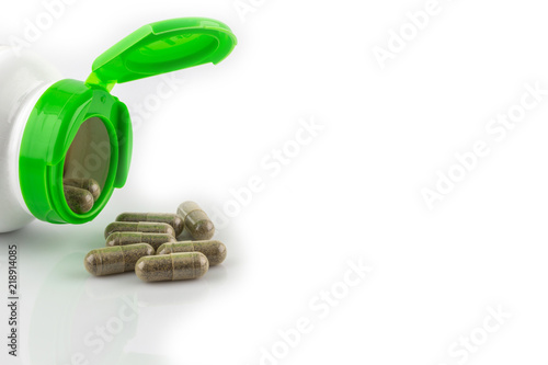 Green hearb pills an pill bottle on white photo