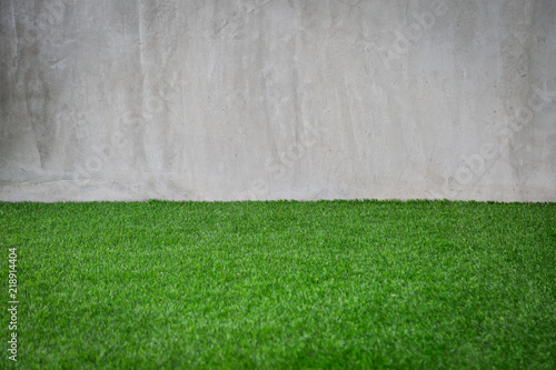 Green grass artificial turf pattern with gray cement wall