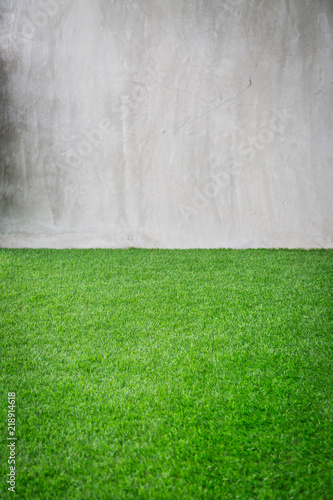 Green grass artificial turf pattern with gray cement wall
