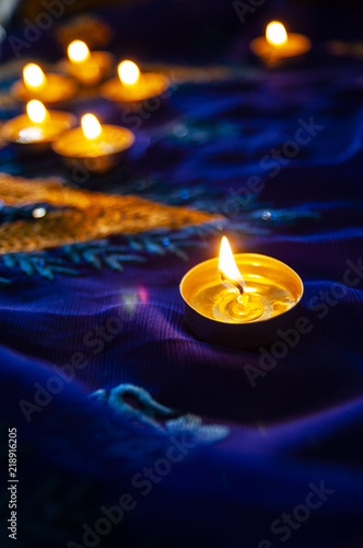 Flame candle lamps for the evening prayers. Diwali lighting on blue sari with golden embroidery