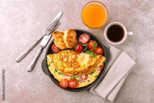 Herb omelette with tomatoes and panini toasts. Coffee. Breakfast