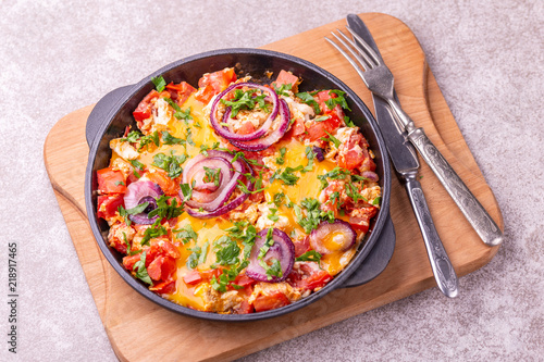 Shakshuka with toasts. Fried eggs with tomatoes, vegetables and herbs