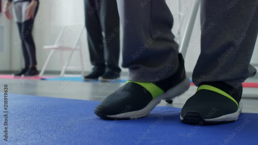 PAN with low-section of legs of unrecognizable senior people in sportswear walking in place during fitness class PAN with low-section of legs of unrecognizable senior people in sportswear walking in place during fitness class