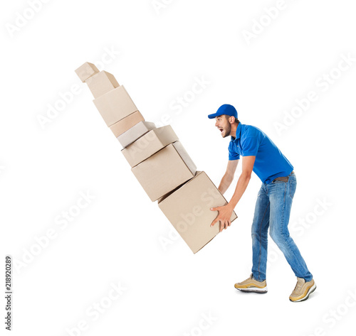 Photo Young delivery man with falling stack of boxes