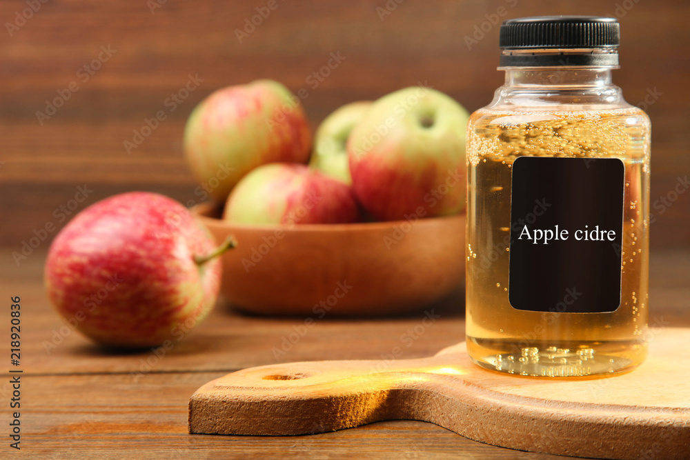 Apple cider in a jar on a brown wooden background. Apple cider in a jar on a brown wooden background.