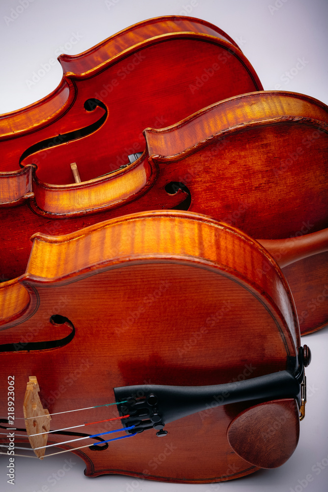 Obraz premium Three violins on a wihte background