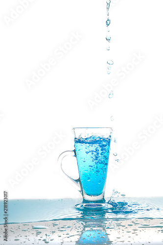Water splashing into glass of water on white