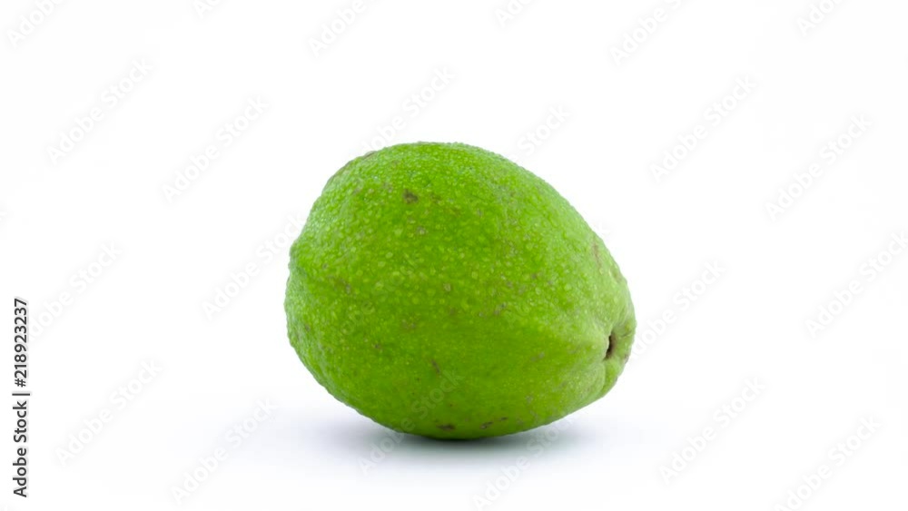 One whole apple guava fruit with water drops. Rotating on the turntable isolated on the white background. Close up. Macro. One whole apple guava fruit with water drops. Rotating on the turntable isolated on the white background. Close up. Macro.