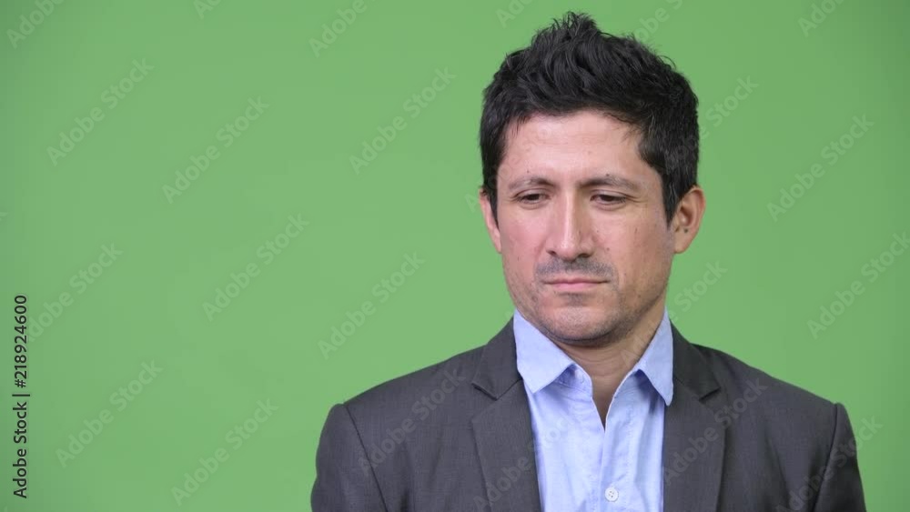 Headshot of serious Hispanic businessman thinking Headshot of serious Hispanic businessman thinking