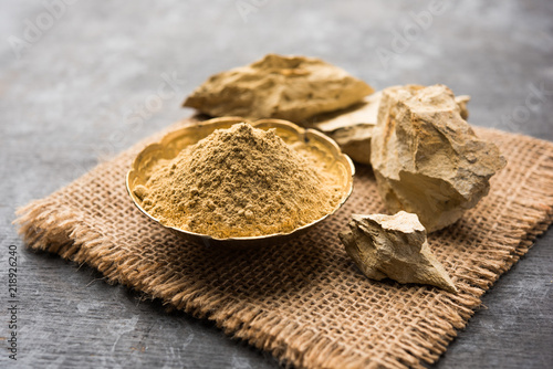 Fuller'S Earth Clay OR Multani mitti in a bowl along with raw stones and mortar photo