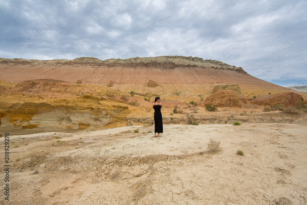 young woman in a black dress in the desert