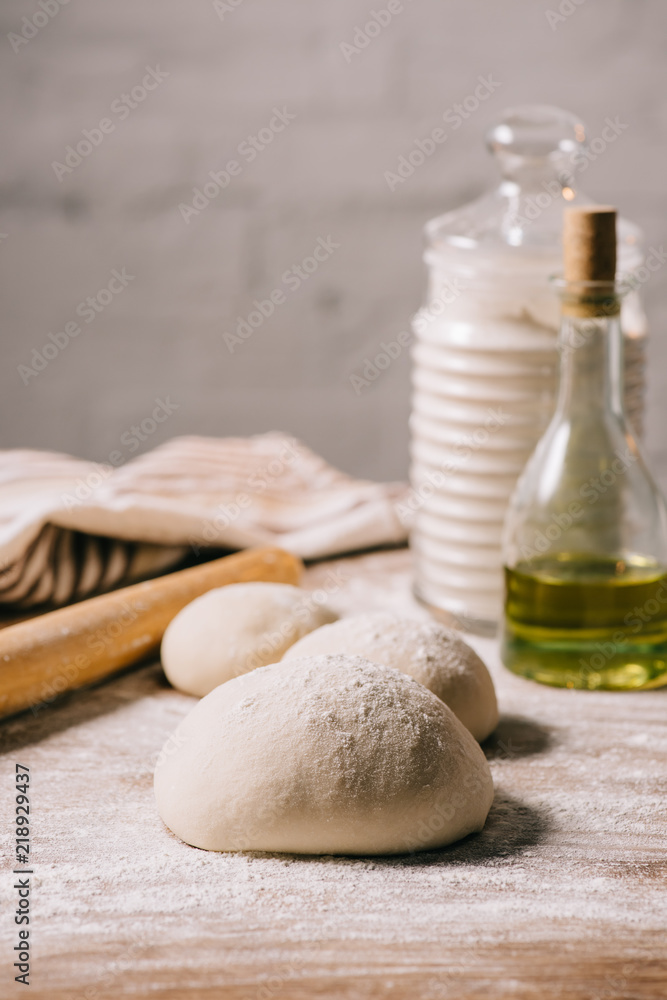 Fototapeta premium selective focus of raw dough for pizza and ingredients on tabletop