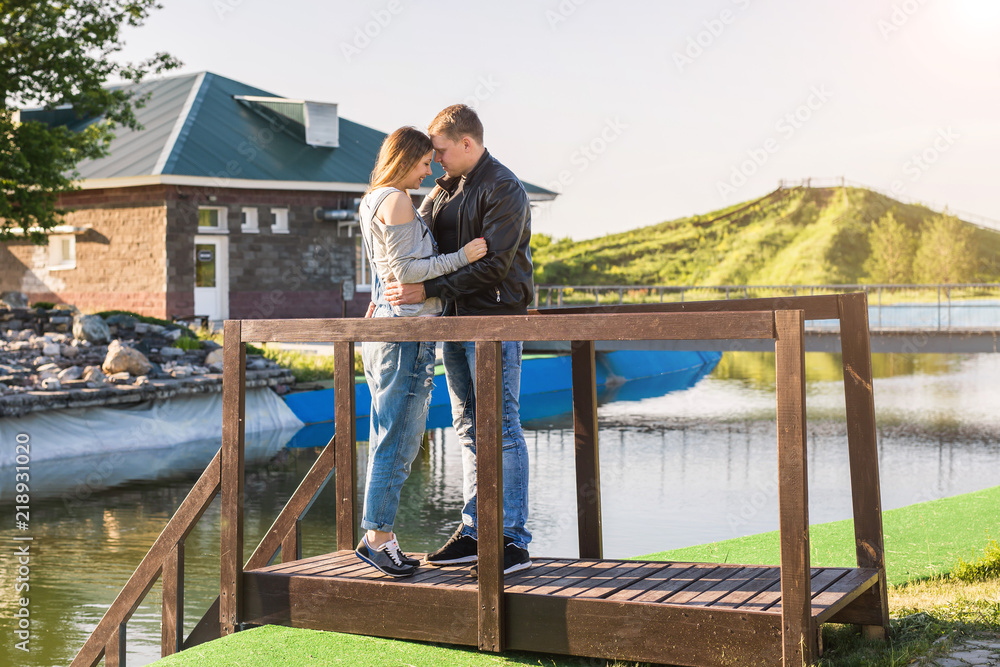 Family and people concept - Young man embracing his pregnant wife's belly on nature background