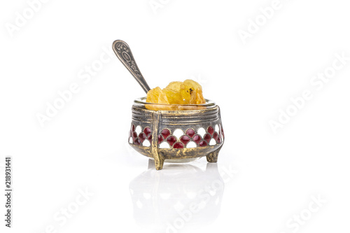 Lot of whole dry golden raisins sultana variety in small caviar bowl isolated on white background photo