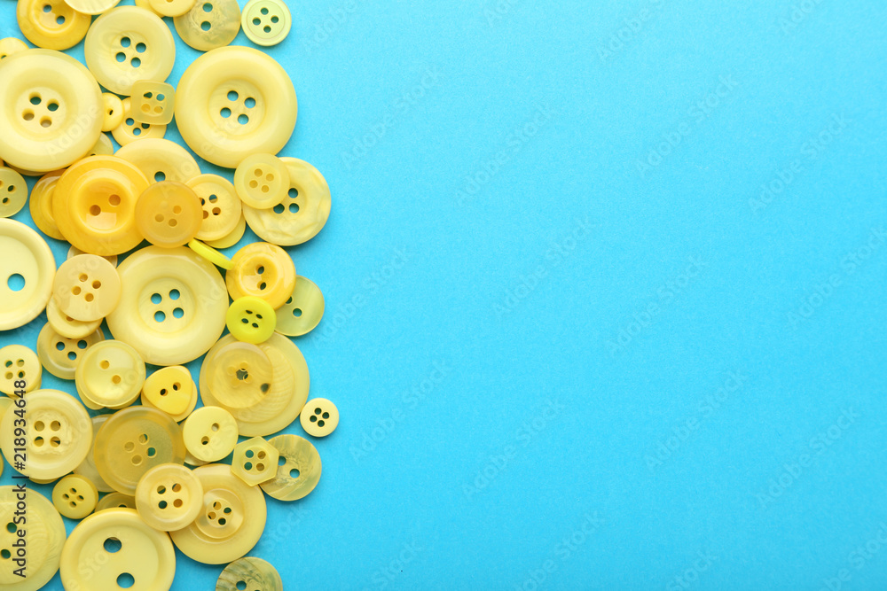 Fototapeta premium Yellow sewing buttons on blue background
