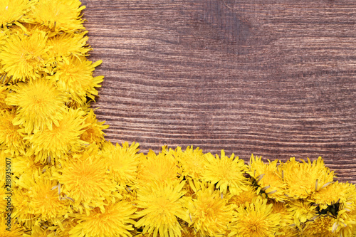 Fototapeta Naklejka Na Ścianę i Meble -  Yellow dandelions on brown wooden table