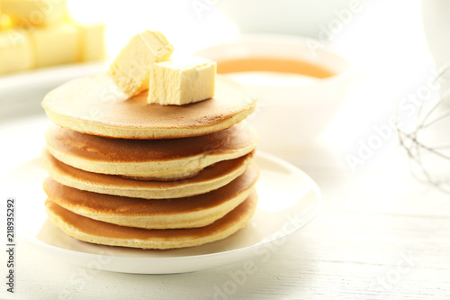 Tasty pancakes with butter on white wooden table