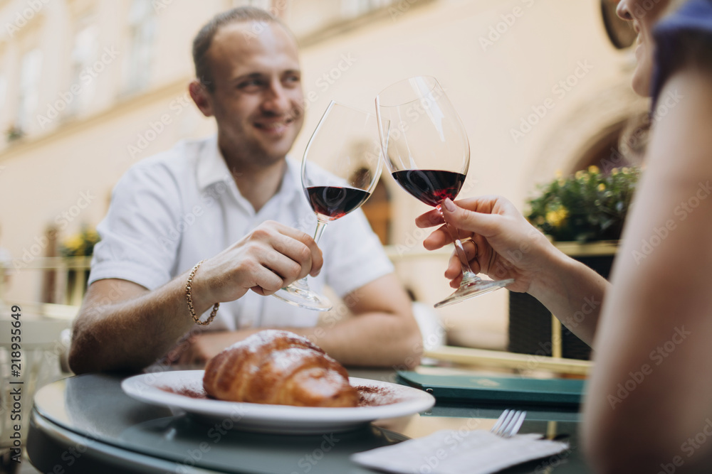 Cheerful couple in a restaurant with glasses of red wine. Young Cheerful couple in a restaurant with glasses of red wine. Young