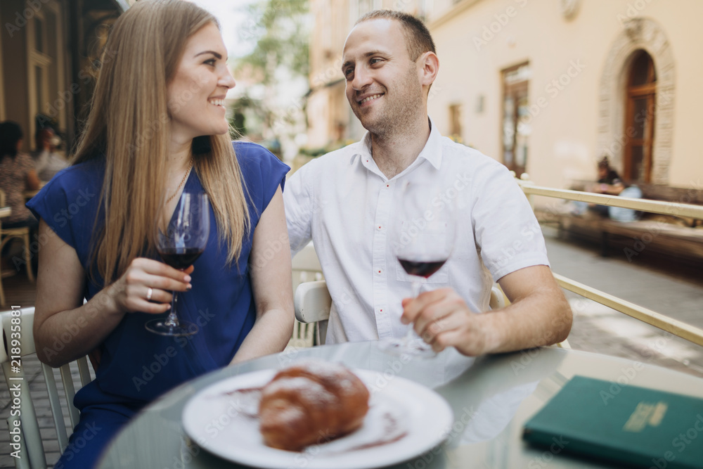 Young couple with glasses of red wine in a restaurant . Young couple with glasses of red wine in a restaurant .