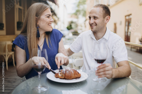 Cheerful couple in a restaurant with glasses of red wine. Young