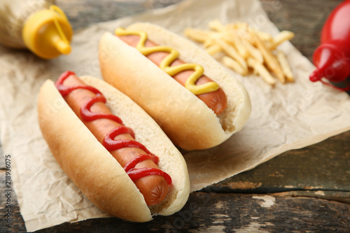 Sticker Hot dogs with mustard and ketchup on wooden table