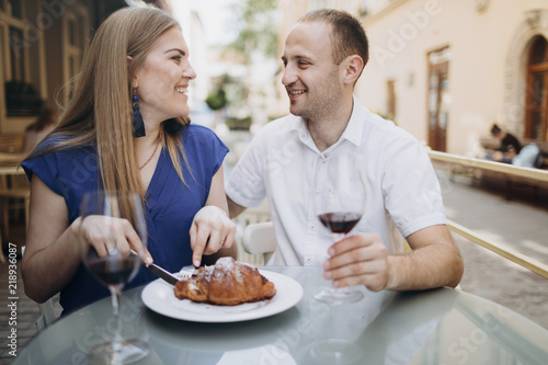 Cheerful couple in a restaurant with glasses of red wine. Young