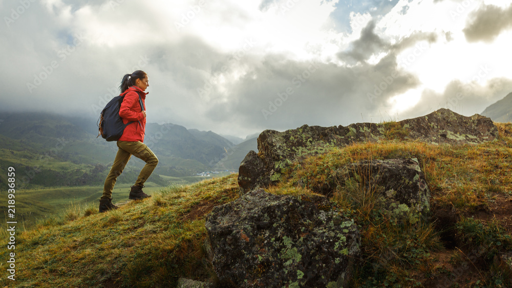 Discovery Travel Destination Holiday Concept. Young Hiker Woman With Backpack Rises To The Mountain Top
