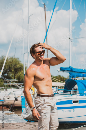Sexy man on sailboat, relaxation in luxury sea cruise, summertime leisure time on water transport, freedom and enjoyment concept 