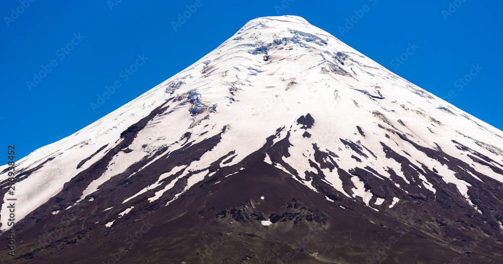 The top of the volcano Osorno in national park Vicente Perez Rosales, Chile. Isolated on blue background.