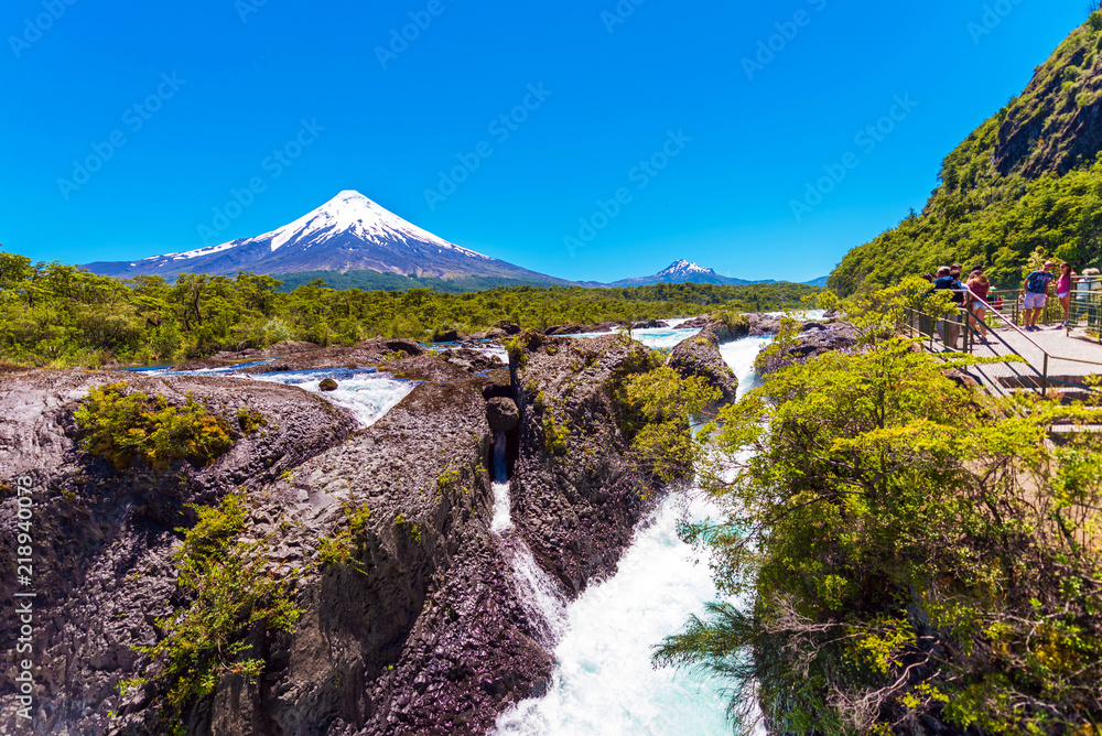 Fototapeta premium Salutos de Petrohue waterfalls and volcano Osorno, Puerto Varas, Chile. Copy space for text.