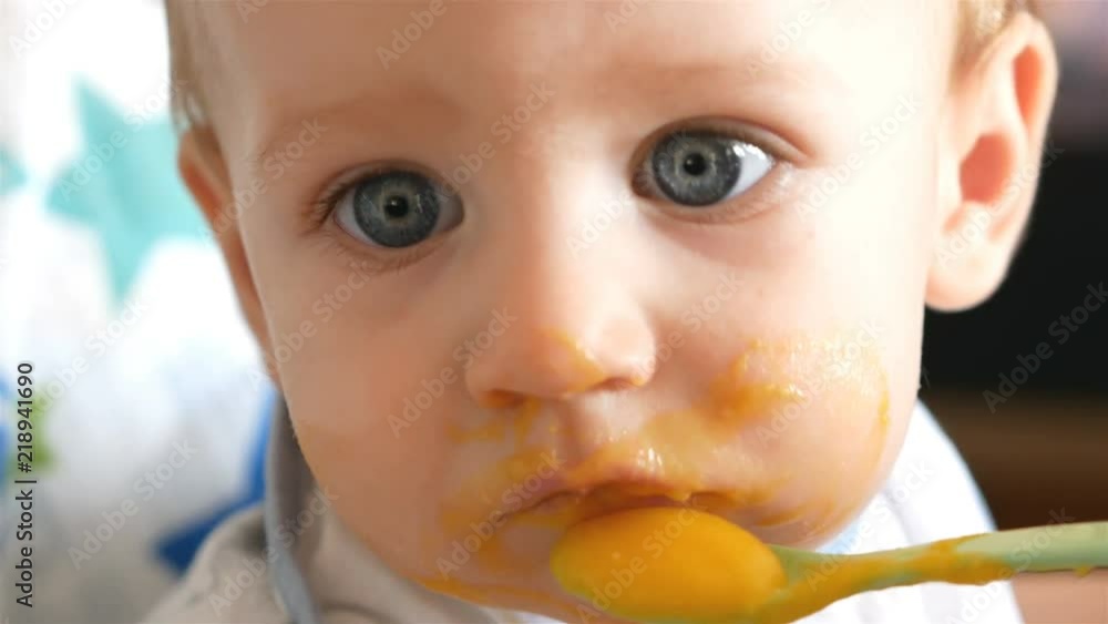 Mom feeding adorable baby boy with blue eyes and bright hair close up Mom feeding adorable baby boy with blue eyes and bright hair close up