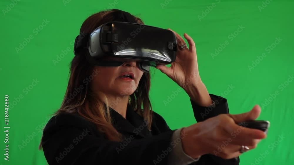 Hispanic woman trying Virtual Reality headset on green screen Hispanic woman trying Virtual Reality headset on green screen