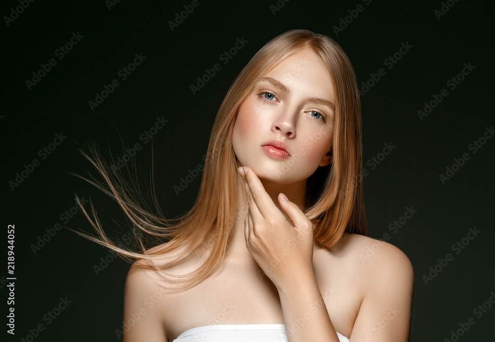 Young girl face beauty skin portrait with long blonde hair with hand over dark background Young girl face beauty skin portrait with long blonde hair with hand over dark background