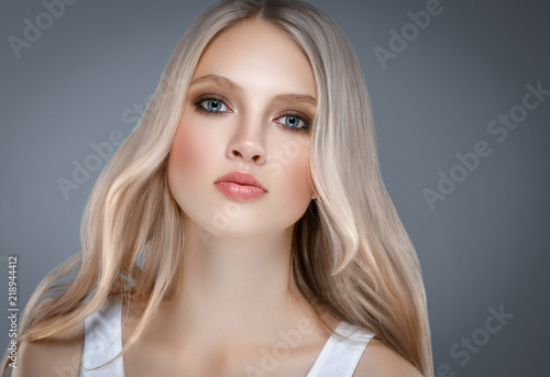 Beautiful Woman Face Portrait Beauty Skin Care Concept with long blonde hair over gray background