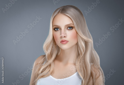 Beautiful Woman Face Portrait Beauty Skin Care Concept with long blonde hair over gray background
