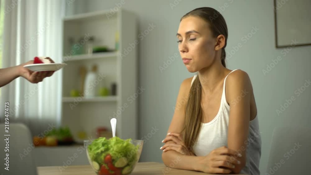 Lean girl choosing between salad and cake, healthy diet vs high-calorie food Lean girl choosing between salad and cake, healthy diet vs high-calorie food