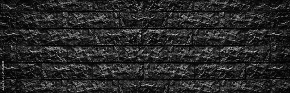 Wide black brick wall texture - stone blocks masonry background Wide black brick wall texture - stone blocks masonry background