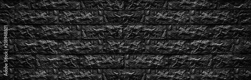 Wide black brick wall texture - stone blocks masonry background