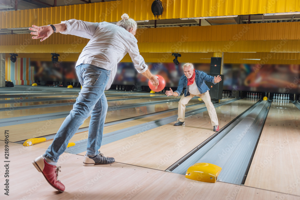 Obraz premium At the weekends. Delighted nice men having fun together while meeting in the bowling club