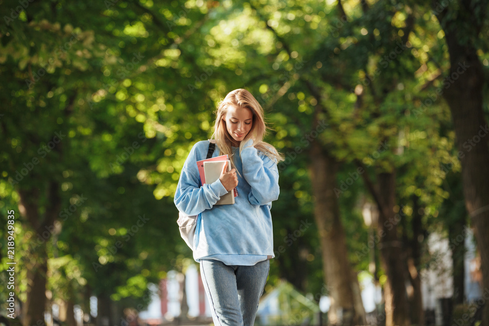 Lovely young girl student with backpack carrying books Lovely young girl student with backpack carrying books
