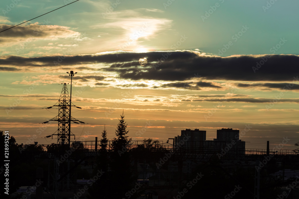The evening comes to the city. Blue sky and sun in the clouds The evening comes to the city. Blue sky and sun in the clouds