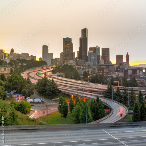 Busy traffic on I-5 Freeway at I-90 interchange during afternoon rush hour with Seattle skylines in background photo