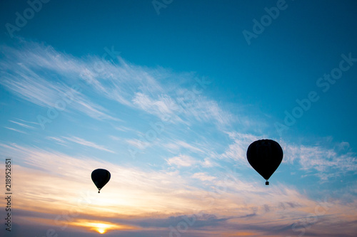 two silhouettes of balloons against the beautiful sunset sky at the festival in Kamyanets Podolsky, Ukraine © Мария Шахматова
