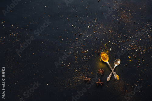 Fotografie, Obraz Assorted spices in spoons with empty space for text on dark black background