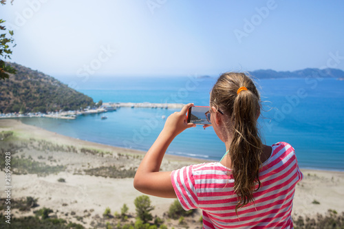 Traveling teenage girl take a photo mountain view, travel concept © Kate