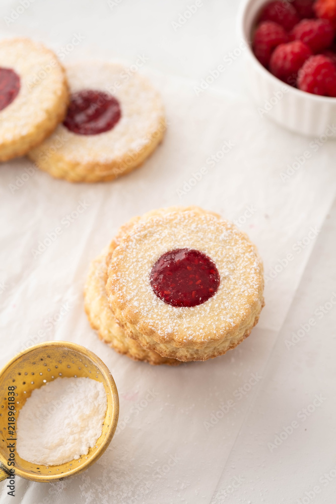 Christmas cookies. Linzer cookies with raspberry jam on white table background. Traditional Austrian biscuits filled. Top view and copy space Christmas cookies. Linzer cookies with raspberry jam on white table background. Traditional Austrian biscuits filled. Top view and copy space