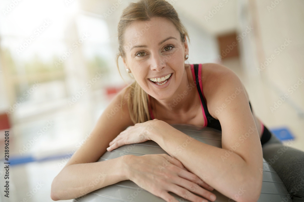 Woman at the gym relaxing on fitness ball