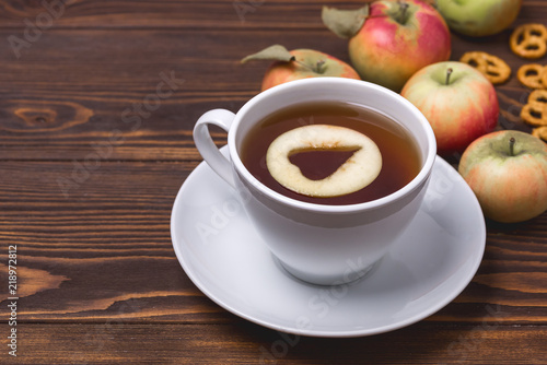 Black Hot Apple Tea in White Cup Ripe Apples Wooden Background Copy Space Hot Autumn Beverage